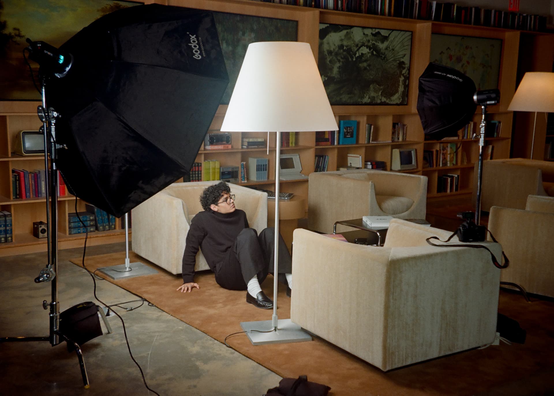 A Creator seated between studio lights at The Lighthouse